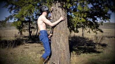 Horny twink in a dark mask fucks a sex toy that is to a tree in a public wilderness. all gay porn video