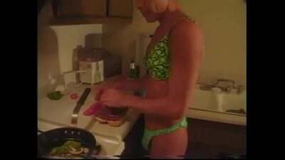 Tanned gay in lingerie prepares dinner in the kitchen while his friend fucks him in the ass all gay porn video